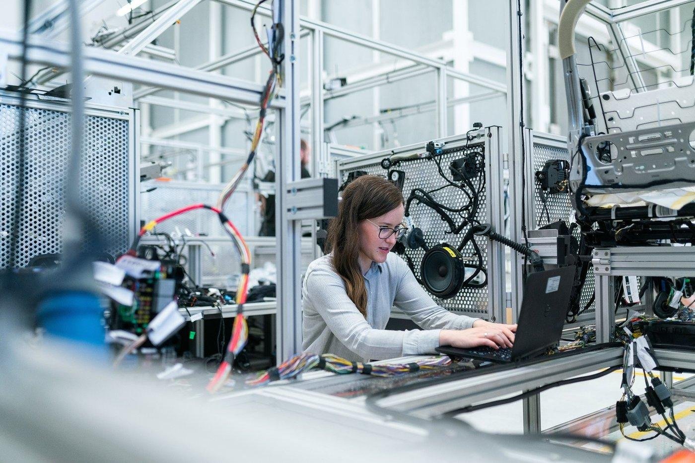 Ingeniera trabajando con precisión en ensamble automotriz